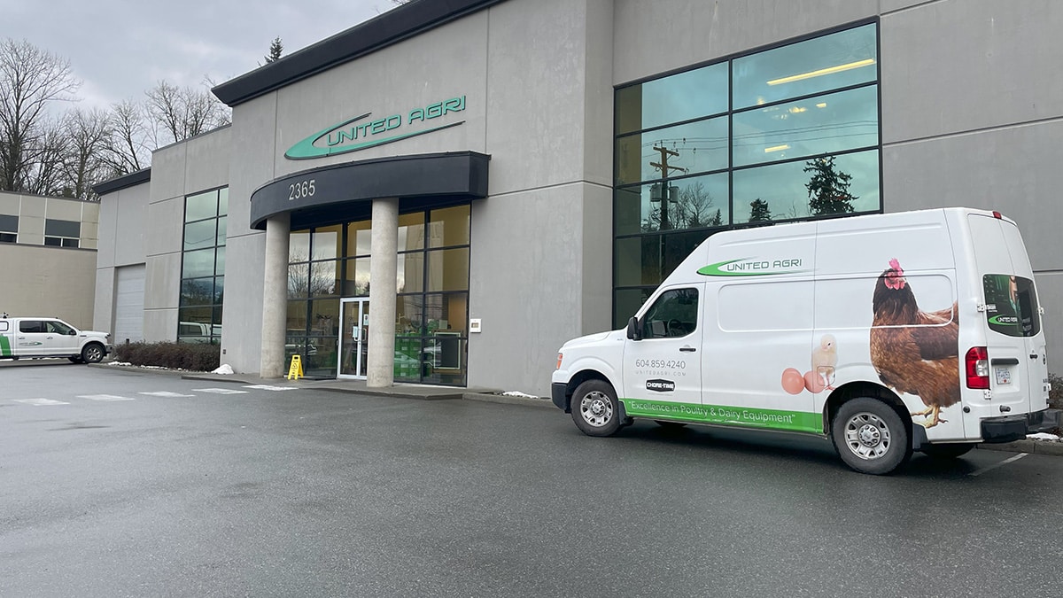 White van with “UNITED AGRI” signage parked outside a commercial building